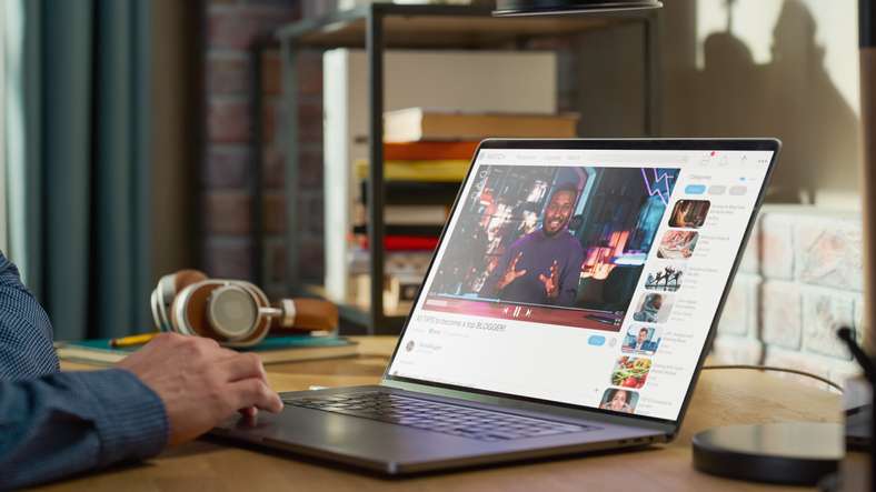 Close Up on Male Hands Using Laptop to Watch Video of African American Influencer