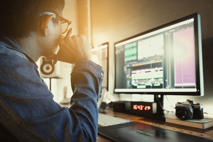 Asian male movie video editor wearing denim jacket, works with footage or video on his personal computer, in his creative office studio. Businessman touching the brain working of Artificial Intelligence (AI) Automation, Predictive analytics, Customer service AI-powered chatbot, analyze customer data, business and technology