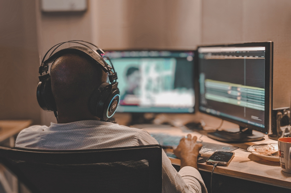 back of male asian producer arranging a song in home studio, music production technology concept